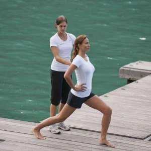 Dehnübungen mit einem Personal Trainier am Steg