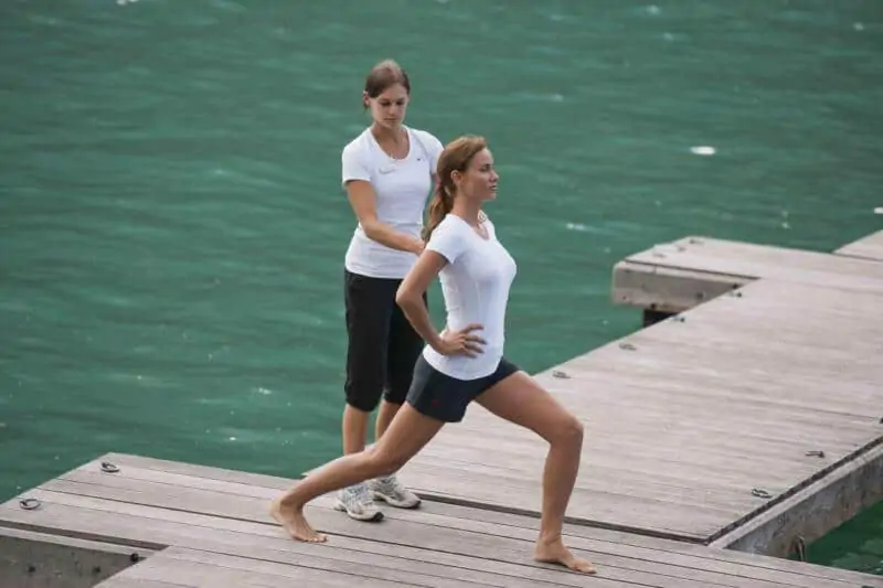 Dehnübungen mit einem Personal Trainier am Steg